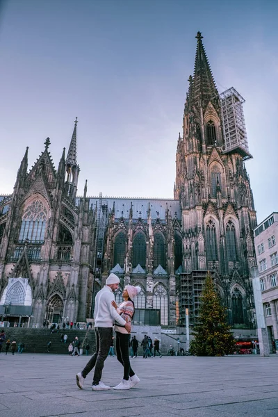 Pareja joven visita el mercado de Navidad en Colonia Alemania durante un viaje a la ciudad, hombres y mujeres en el mercado de Navidad — Foto de Stock