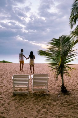 Çiftler Khao Lak Tayland sahilinde gün batımını izliyorlar.