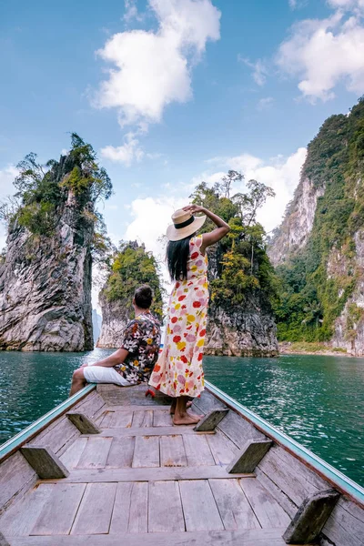 Pasangan bepergian dengan perahu menjelajahi tebing batu kapur epik di danau besar di Taman Nasional Khao Sok, danau Chiew lan, Thailand — Stok Foto