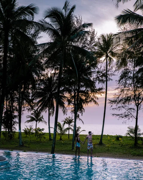 Coppia che guarda il tramonto sulla spiaggia e la piscina di un resort di lusso in Thailandia Khao Lak — Foto Stock