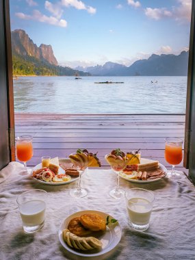 Khao Sok Gölü 'ndeki yüzen ahşap bungalovun önünde kahvaltı Tayland Ulusal Parkı
