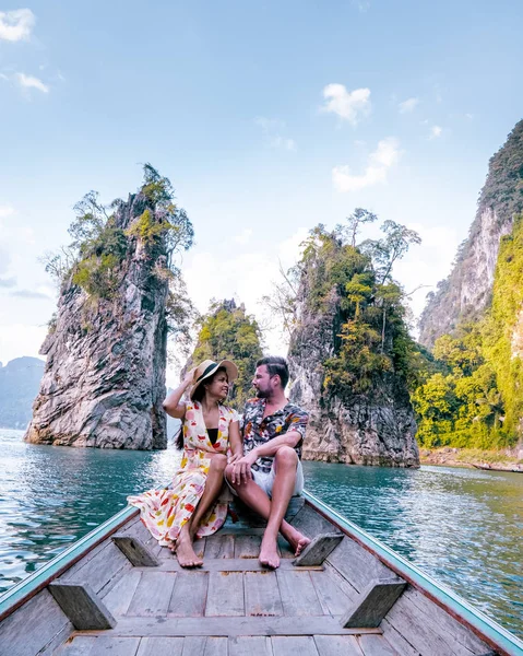 Pasangan bepergian dengan perahu menjelajahi tebing batu kapur epik di danau besar di Taman Nasional Khao Sok, danau Chiew lan, Thailand — Stok Foto