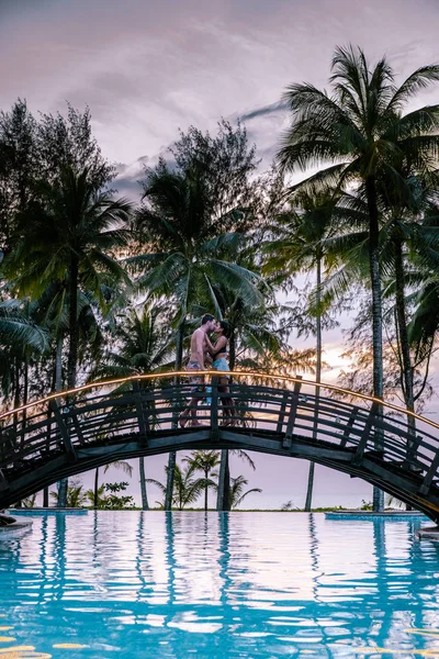 Coppia che guarda il tramonto sulla spiaggia e la piscina di un resort di lusso in Thailandia Khao Lak — Foto Stock