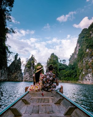 Khao Sok Tayland, Khao Sok Tayland 'da tatil yapan genç bir çift göl boyunca tekneyle seyahat ediyor.
