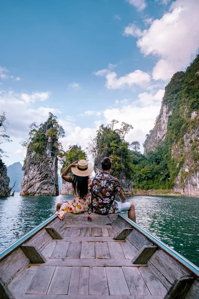 Pasangan bepergian dengan perahu menjelajahi tebing batu kapur epik di danau besar di Taman Nasional Khao Sok, danau Chiew lan, Thailand — Stok Foto