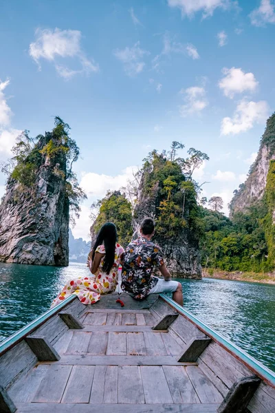 Pasangan bepergian dengan perahu menjelajahi tebing batu kapur epik di danau besar di Taman Nasional Khao Sok, danau Chiew lan, Thailand — Stok Foto