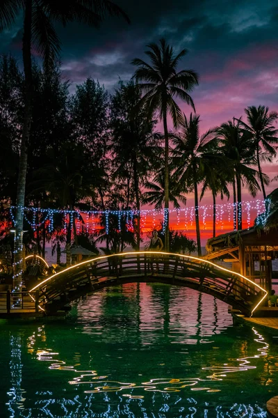 Çiftler kumsalda gün batımını ve Tayland 'da lüks bir tatil köyü olan Khao Lak' ın havuzunu izliyorlar. — Stok fotoğraf