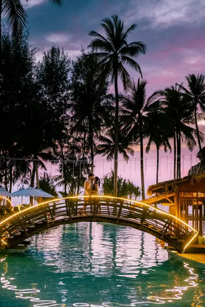 Coppia che guarda il tramonto sulla spiaggia e la piscina di un resort di lusso in Thailandia Khao Lak — Foto Stock