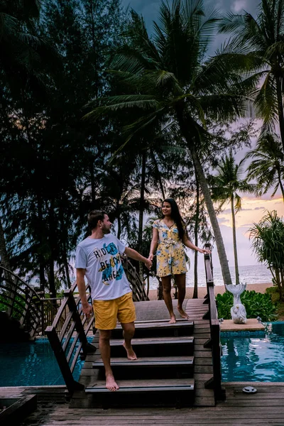 Coppia che guarda il tramonto sulla spiaggia e la piscina di un resort di lusso in Thailandia Khao Lak — Foto Stock