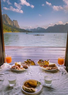 Khao Sok Gölü 'ndeki yüzen ahşap bungalovun önünde kahvaltı Tayland Ulusal Parkı