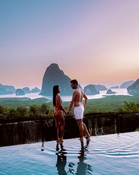 Phangnga Bay Ταϊλάνδη, ζευγάρι στην άκρη μιας πισίνας βλέποντας την ανατολή του ηλίου, άνδρες και γυναίκες διακοπές Ταϊλάνδη παρακολουθήσετε την ανατολή του ηλίου πισίνα — Φωτογραφία Αρχείου