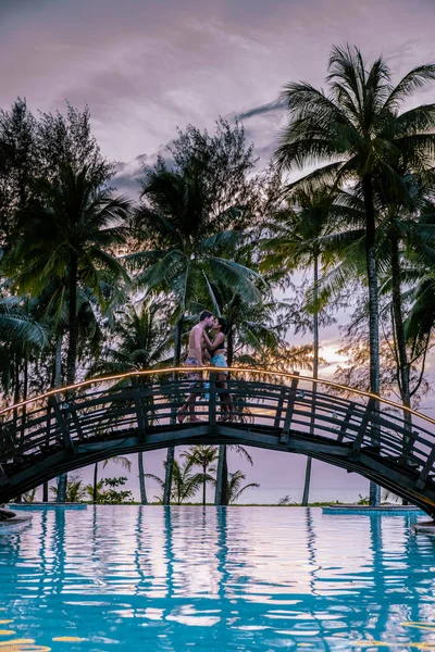 Ζευγάρι βλέποντας ηλιοβασίλεμα από την παραλία και την πισίνα ενός πολυτελούς θέρετρου στην Ταϊλάνδη Khao Lak — Φωτογραφία Αρχείου
