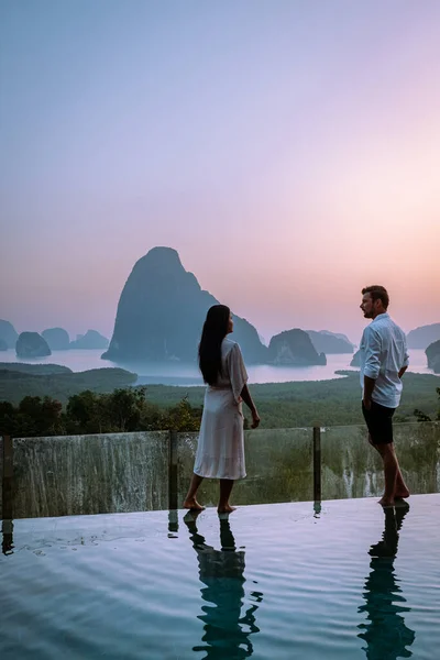 Miradouro da baía de Phanga, casal assistindo ao nascer do sol na beira de uma piscina, piscina infinita olhando para fora sobre Phangnga Bay Tailândia — Fotografia de Stock