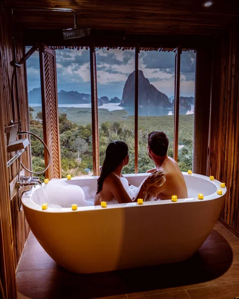 Pareja en vacaciones de luna de miel, Bañera con una mirada sobre la bahía de Phangnga, Baño de madera de lujo durante la puesta del sol Tailandia Asia —  Fotos de Stock