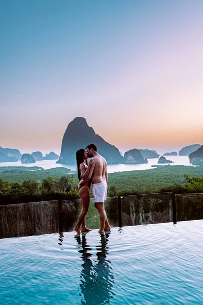 Phangnga Bay Thaïlande, couple au bord d'une piscine regardant lever de soleil Thaïlande piscine à débordement — Photo