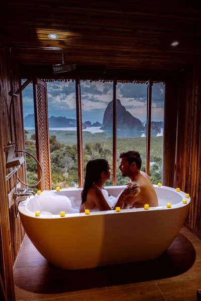 Pareja en vacaciones de luna de miel, Bañera con una mirada sobre la bahía de Phangnga, Baño de madera de lujo durante la puesta del sol Tailandia Asia —  Fotos de Stock