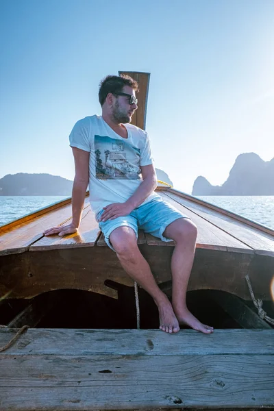 Young men traveling in longtail boat, Phangnga Bay Thailand ocean, famous for its many Islands and lagoon in the ocean — Stok fotoğraf