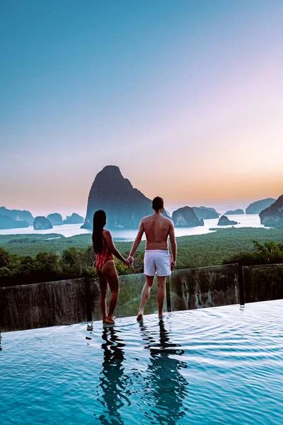 Phangnga Bay Thailandia, coppia sul bordo di una piscina a guardare l'alba Thailandia piscina a sfioro — Foto Stock