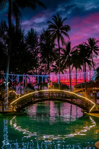 Çiftler kumsalda gün batımını ve Tayland 'da lüks bir tatil köyü olan Khao Lak' ın havuzunu izliyorlar. — Stok fotoğraf