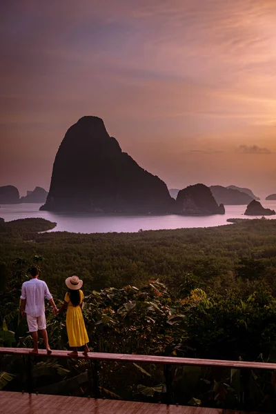 Couple watching sunrise over the bay of Phangnga Thailand, men and woman at Samet Nang She viewpoint during sunrise Thailand — Stockfoto