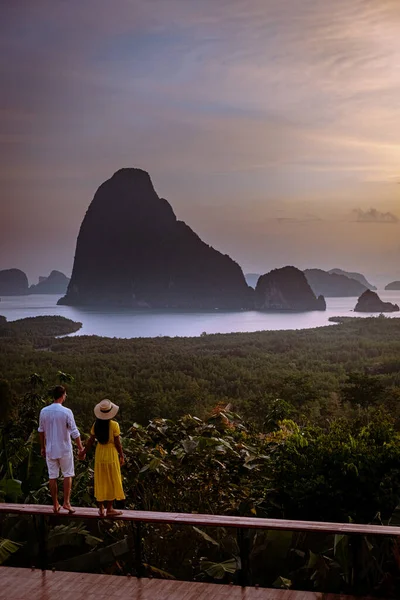 Couple watching sunrise over the bay of Phangnga Thailand, men and woman at Samet Nang She viewpoint during sunrise Thailand — Stockfoto