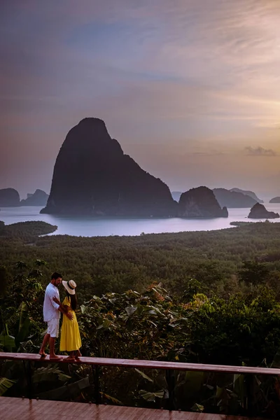 Couple watching sunrise over the bay of Phangnga Thailand, men and woman at Samet Nang She viewpoint during sunrise Thailand — Stockfoto