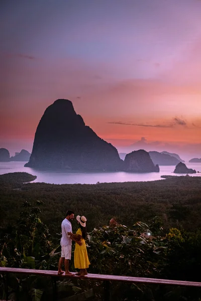 Couple watching sunrise over the bay of Phangnga Thailand, men and woman at Samet Nang She viewpoint during sunrise Thailand — Stockfoto