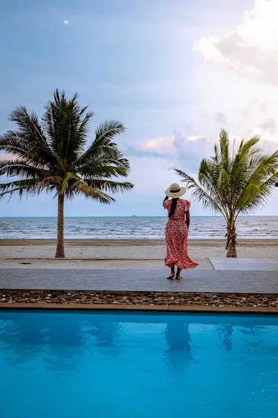 Mujer en la playa con palmera y piscina en Tailandia Zona de Chumphon durante el atardecer en la playa de Arunothai — Foto de Stock