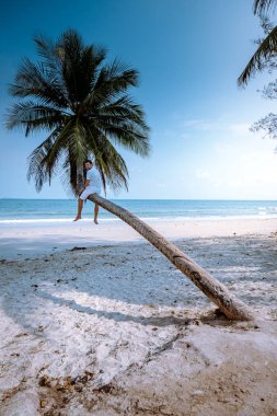 Thung Wua Laen beach Chumphon Thailand, men on the beach by palm tree hanging on the white beach 