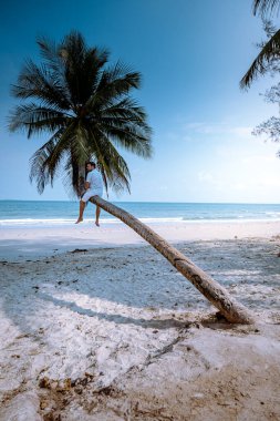 Thung Wua Laen beach Chumphon Thailand, men on the beach by palm tree hanging on the white beach 