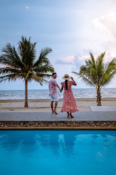 Couple on the beach with palm tree and swimming pool in Thailand Chumphon area during sunset at Arunothai beach — Stok fotoğraf