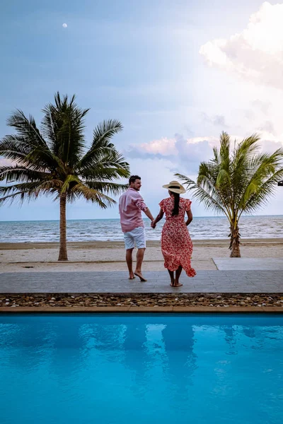 Couple on the beach with palm tree and swimming pool in Thailand Chumphon area during sunset at Arunothai beach — Stok fotoğraf