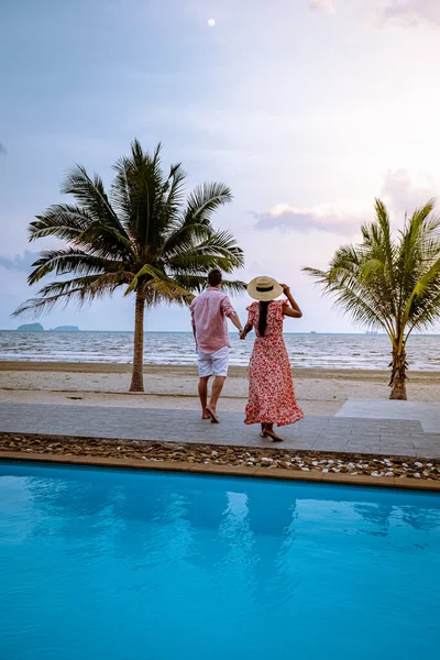 Paar op het strand met palmboom en zwembad in Thailand Chumphon gebied tijdens zonsondergang op Arunothai strand — Stockfoto