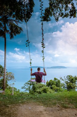 Chumphon Thailand, Khao Matsee Viewpoint view over ocean of Chumphon, men in swing above ocean