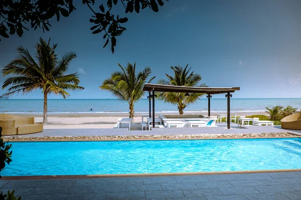 Beach with palm tree and swimming pool in Thailand Chumphon area during sunset at Arunothai beach — 图库照片