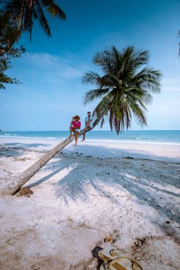 Wua Laen plajı Chumphon bölgesi Tayland, plajda asılı duran palmiye ağacı ve Tayland 'da tatil yapan bir çift.