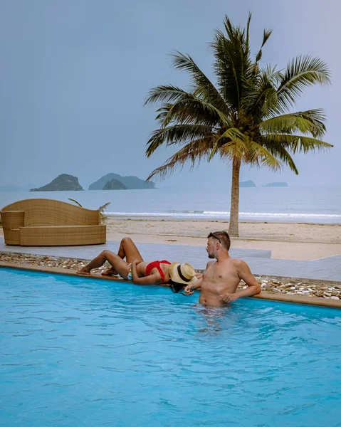 Pareja de hombres y mujeres durante el amanecer junto a la piscina con vistas a la playa de Chumphon Tailandia —  Fotos de Stock