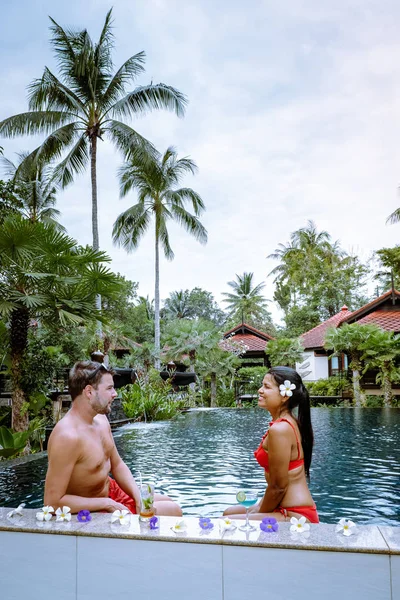 Coppia bere cocktail a bordo piscina durante le vacanze in Thailandia — Foto Stock