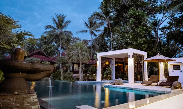 Casa de estilo tailandês com piscina Tailândia durante o pôr do sol — Fotografia de Stock