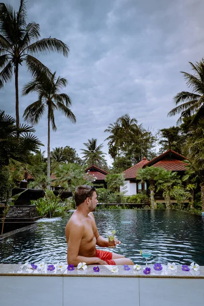 Gars boire des cocktails au bord de la piscine pendant les vacances en Thaïlande — Photo