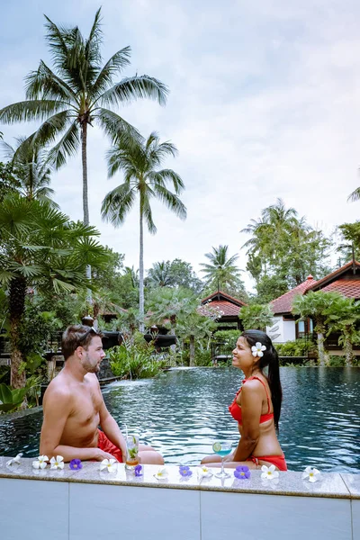 Paar cocktails drinken bij het zwembad tijdens vakantie in Thailand — Stockfoto