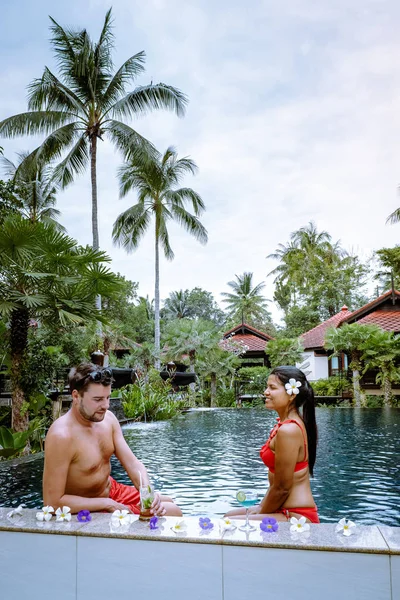 Ζευγάρι πίνοντας κοκτέιλ δίπλα στην πισίνα κατά τη διάρκεια των διακοπών στην Ταϊλάνδη — Φωτογραφία Αρχείου