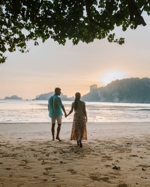 couple during sunset on the beach Krabi Thailand, men and woman watching sunset at Ao Nam Mao beach Krabi Ao Nang area Thailand