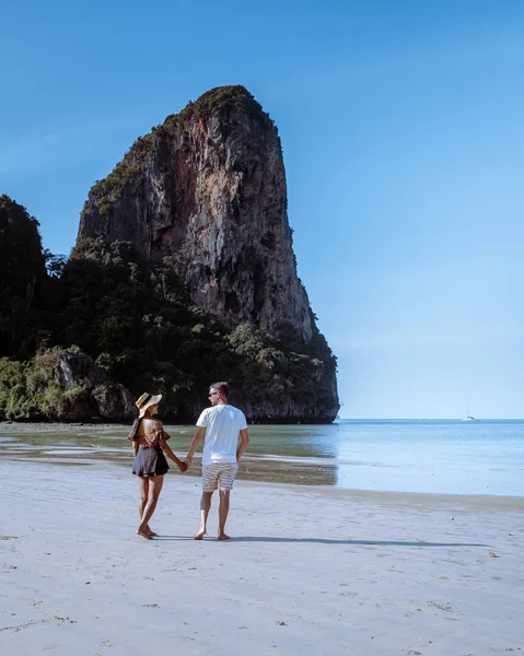 Railay Beach Krabi Thailand, Paar spaziert morgens am Strand mit tropischen Klippen und langen Schwanzbooten im Hintergrund am Insel Railay Strand Krabi — Stockfoto
