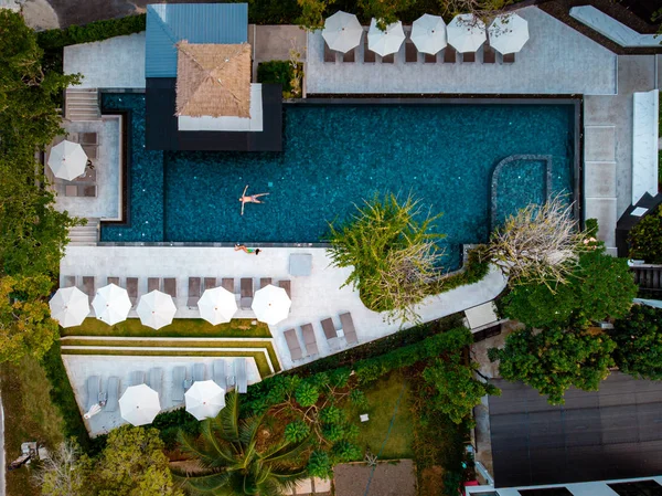 Vista superior piscina, piscina con vistas al dron, pareja en la piscina durante las vacaciones en Tailandia — Foto de Stock