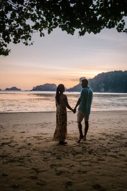 couple during sunset on the beach Krabi Thailand, men and woman watching sunset at Ao Nam Mao beach Krabi Ao Nang area Thailand