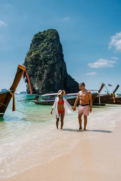 Railay Beach Krabi Thailand, couple walking in the morning on the beach with tropical cliffs and long tail boats on the background at the Island of Railay beach Krabi — ストック写真