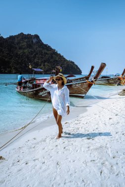 Railay Beach Krabi Thailand, woman on vacation in tropical Thailand, with tropical cliffs and long tail boats 