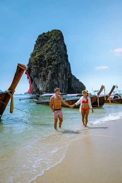 Railay Beach Krabi Thailand, couple walking in the morning on the beach with tropical cliffs and long tail boats on the background at the Island of Railay beach Krabi — 图库照片