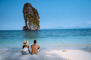 Kumsaldaki çift, Koh Poda Tayland, Tayland 'ın Krabi ilindeki Poda Adası' nın güzel manzarası. Bu adanın beyaz kumsalı var ve kristal berrak suyla çevrili.